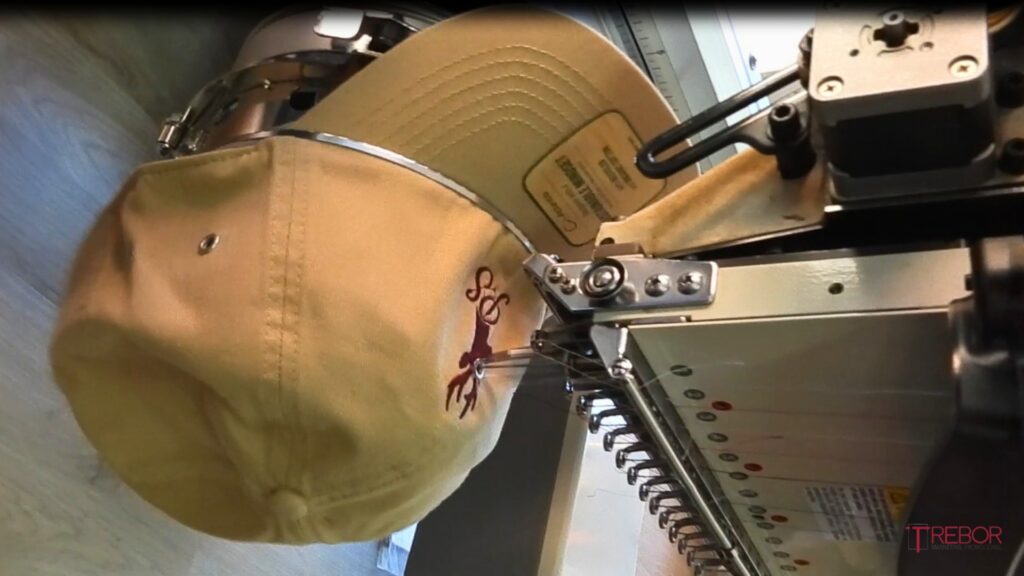 Gorra corporativa siendo personalizada mediante bordado industrial para conseguir un acabado duradero y de alta calidad